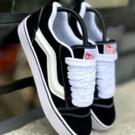 Black sneakers with white laces hanging on a railing, close-up view