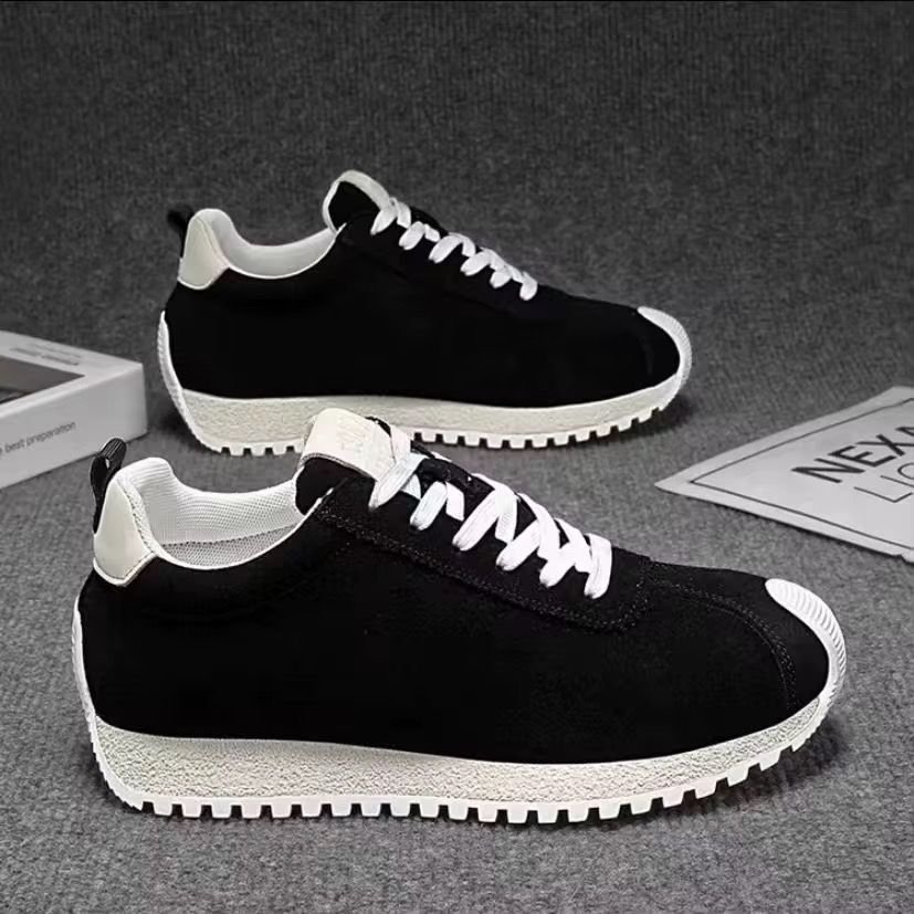 Baskets homme cuir style minimaliste confort urbain Black sneakers with white laces and chunky off-white soles on a gray background